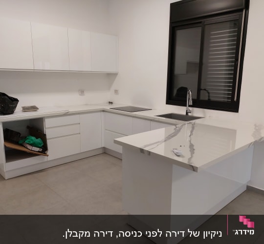 מטבח עם משטחי שיש נקיים וברז נירוסטה
